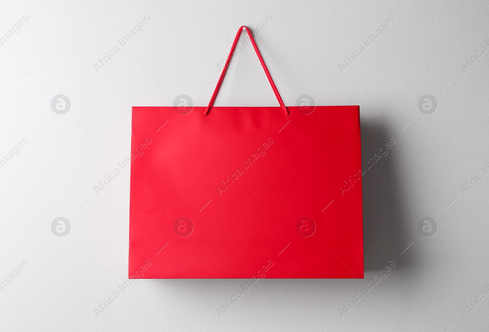 Photo of Paper shopping bag hanging on white wall