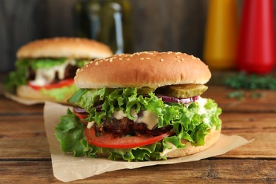 Photo of Delicious burger with beef patty and lettuce on wooden table