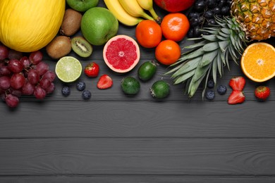 Photo of Different ripe fruits on gray wooden table, top view. Space for text