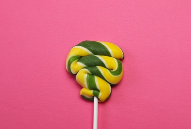 Sweet colorful lollipop on pink background, top view