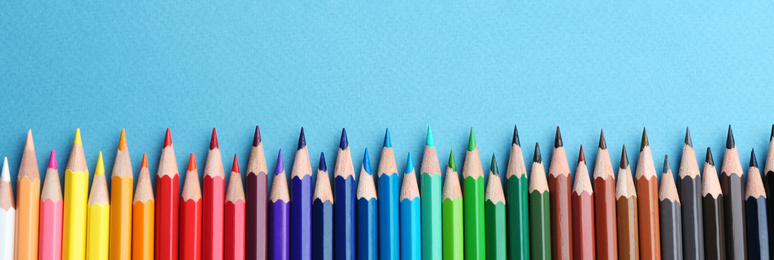 Image of Color pencils on light blue  background, flat lay with space for text. Banner design