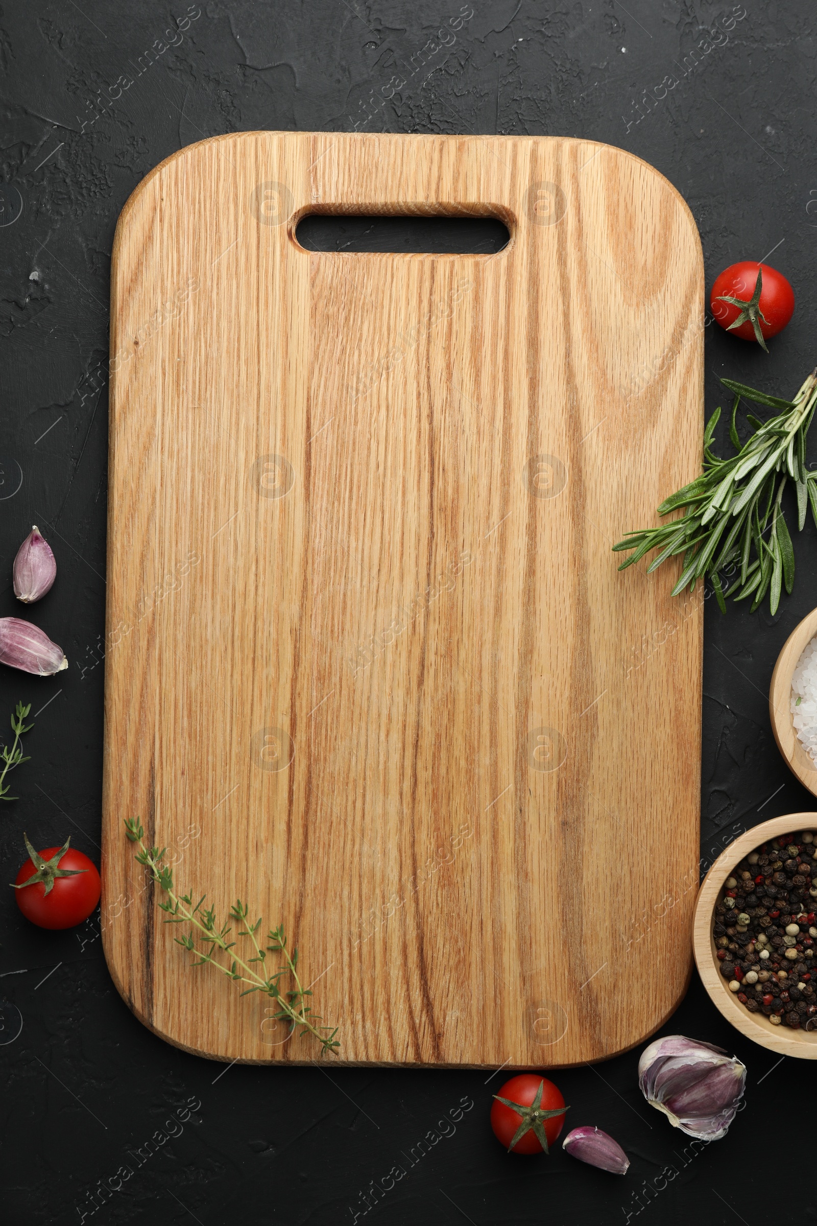 Photo of Cutting board, fresh tomatoes and different spices on grey textured table, flat lay