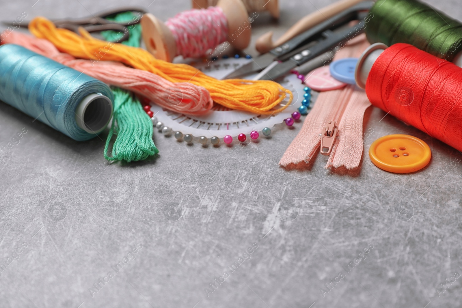 Photo of Composition with threads and sewing accessories on grey background