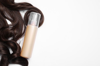 Photo of Spray bottle with thermal protection and lock of brown hair on white background, flat lay. Space for text