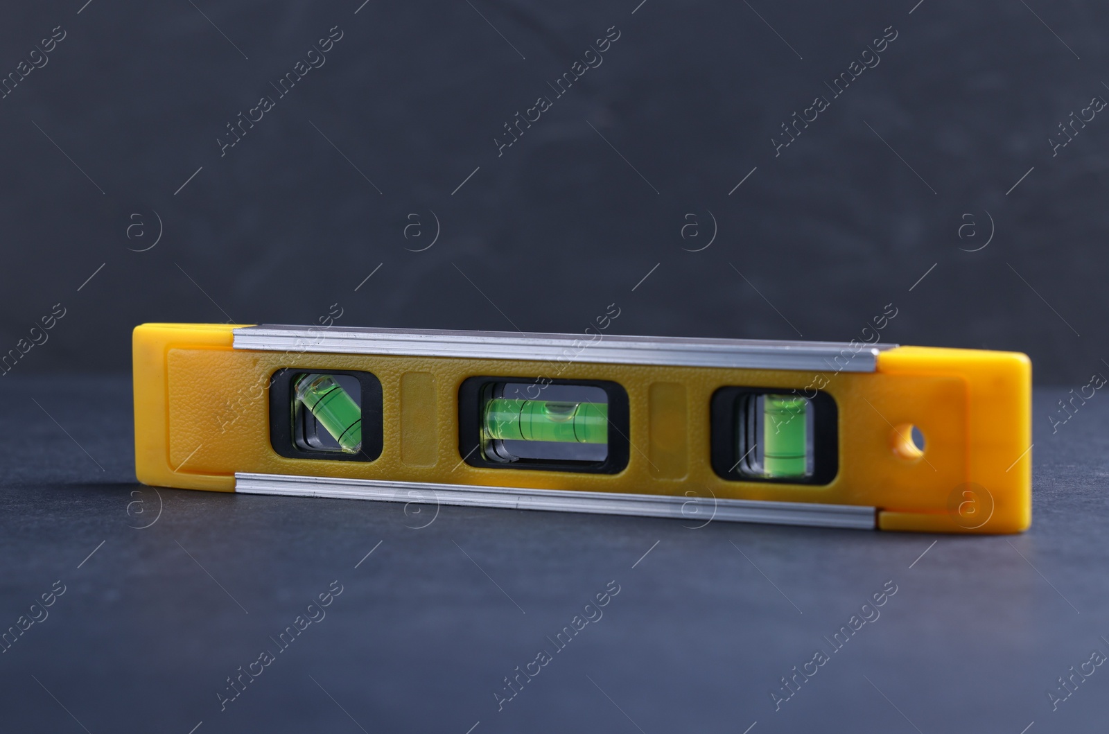 Photo of One yellow building level on dark table