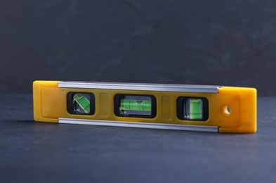 Photo of One yellow building level on dark table