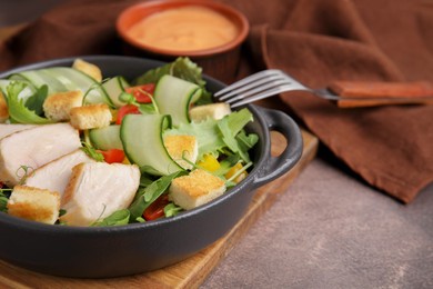 Delicious salad with croutons, chicken and vegetables served on grey table, closeup