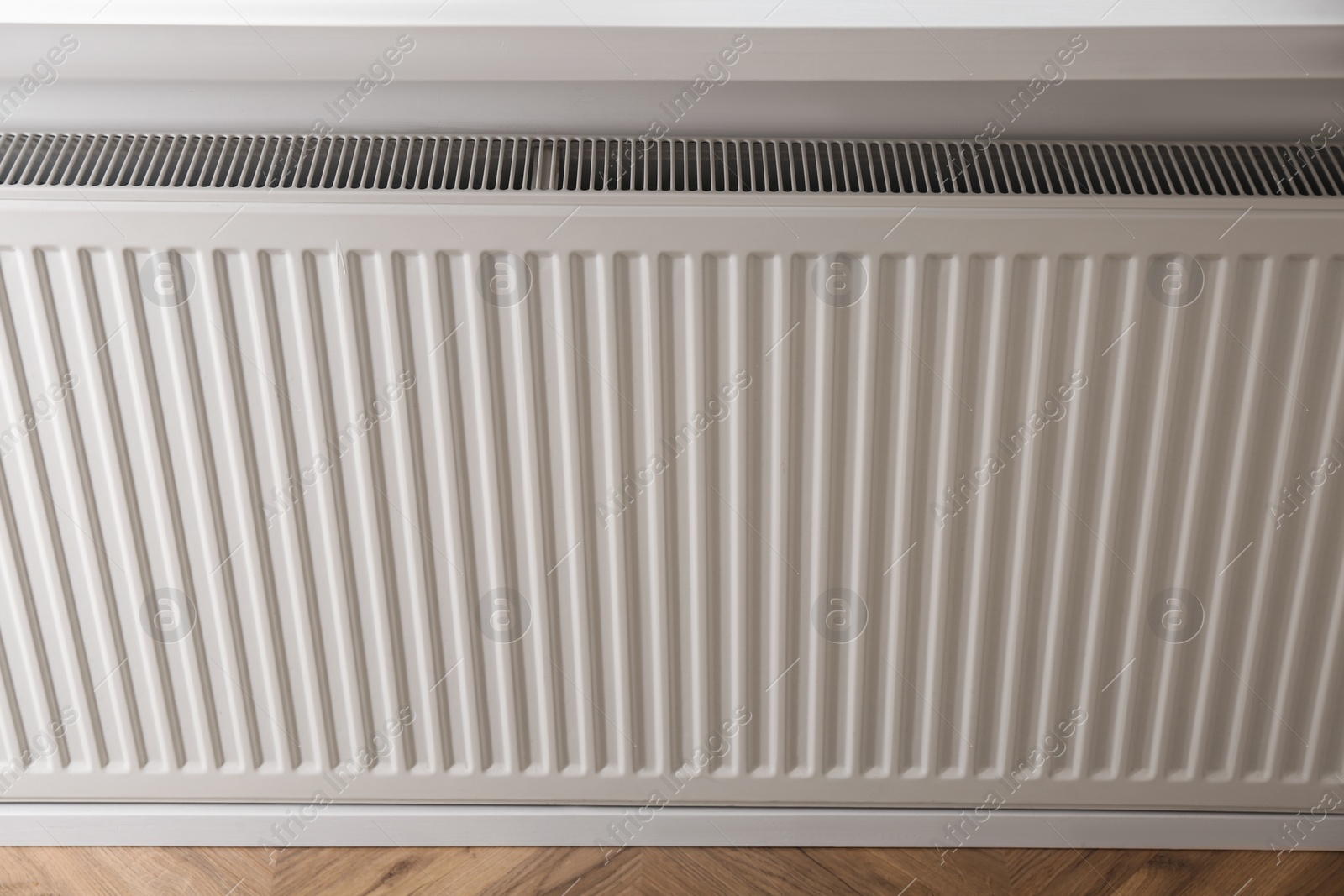 Photo of Closeup view of modern panel radiator indoors