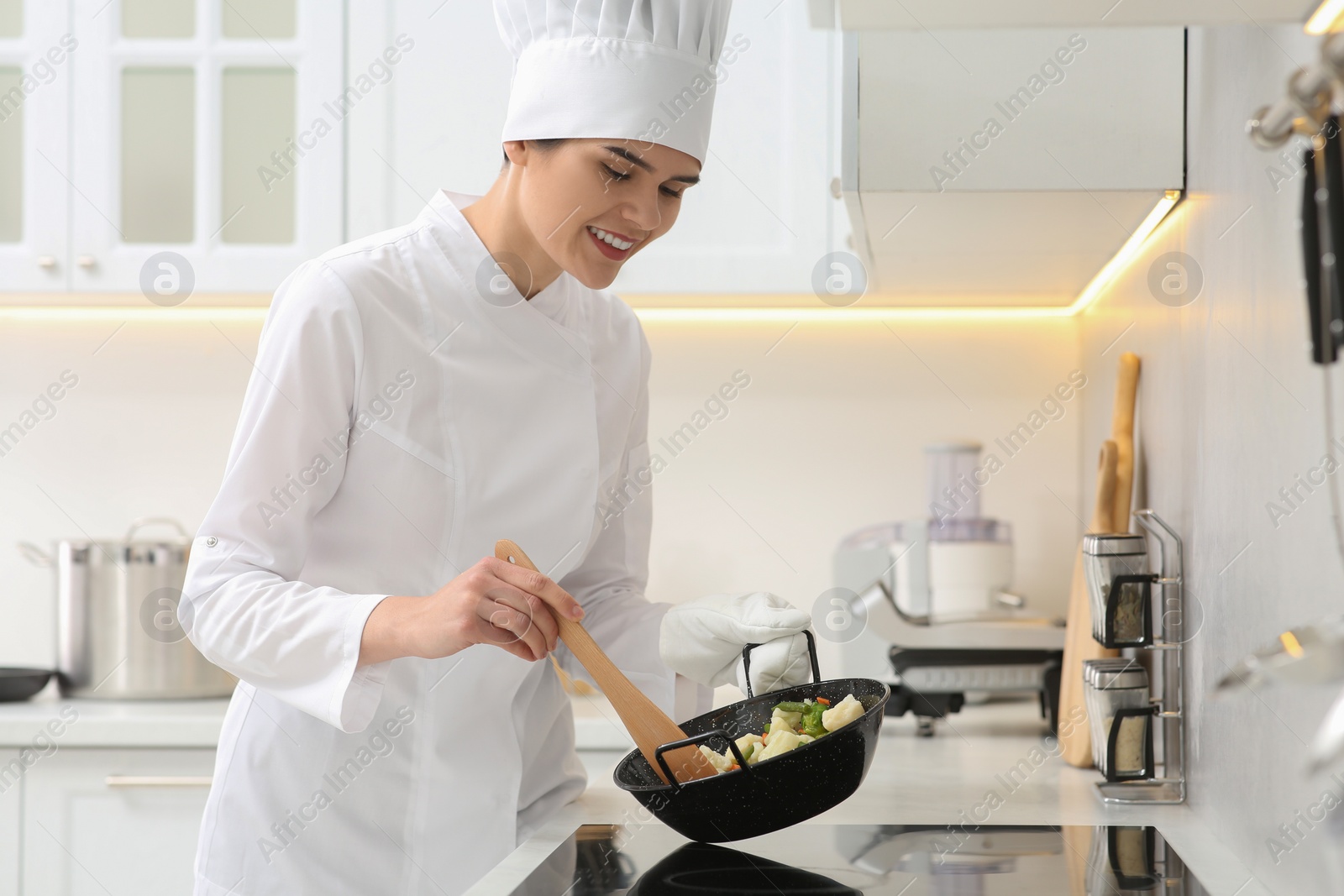 Photo of Professional chef stiring delicious dish in kitchen