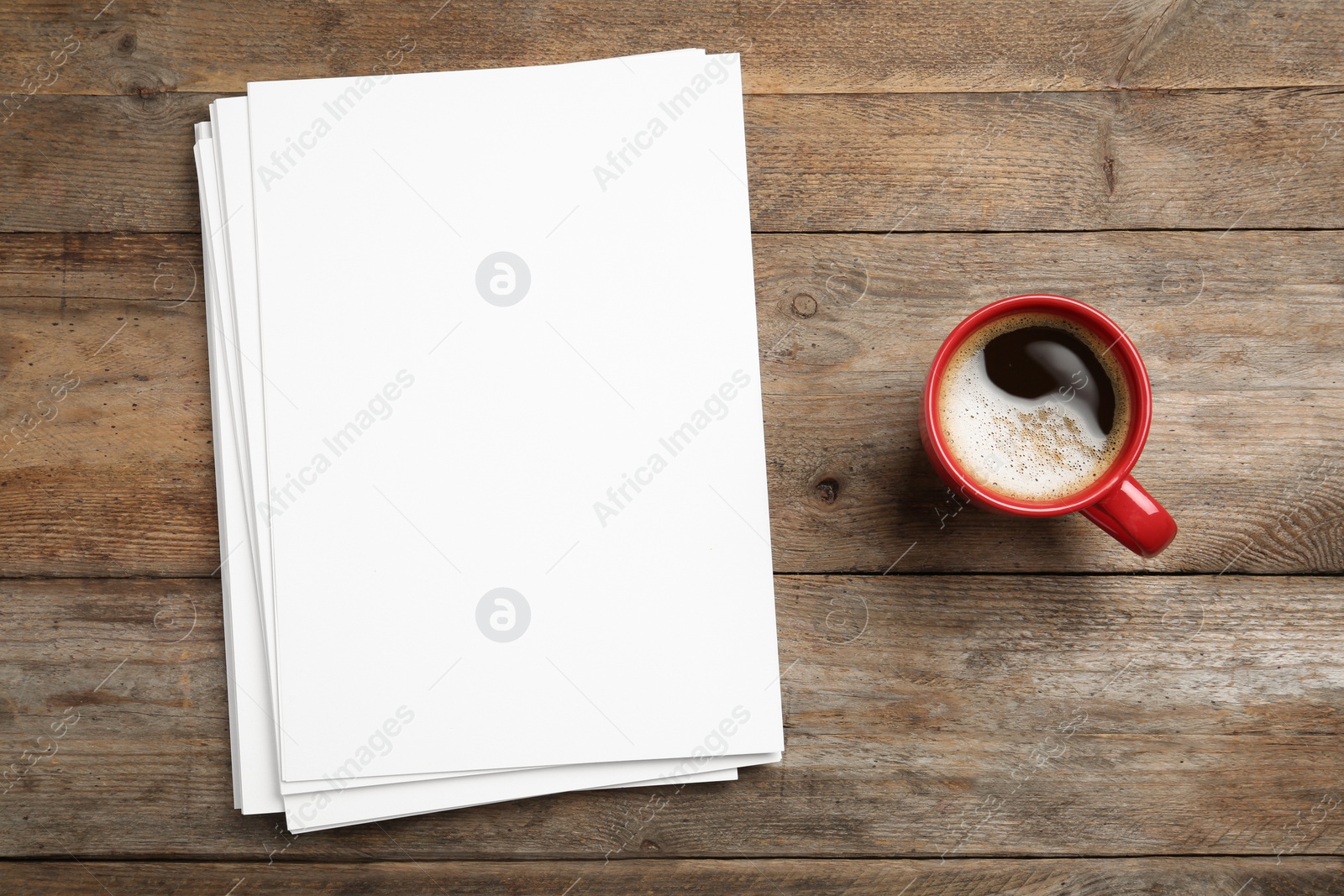 Photo of Blank paper sheets for brochure and cup of coffee on wooden background, flat lay. Mock up