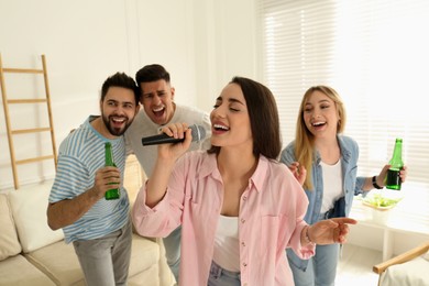 Young woman singing karaoke with friends at home