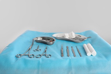 Photo of Different surgical instruments on table against light background