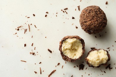 Delicious chocolate truffles on white table, flat lay. Space for text