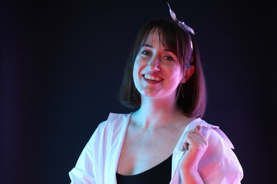 Portrait of happy woman on dark background, space for text