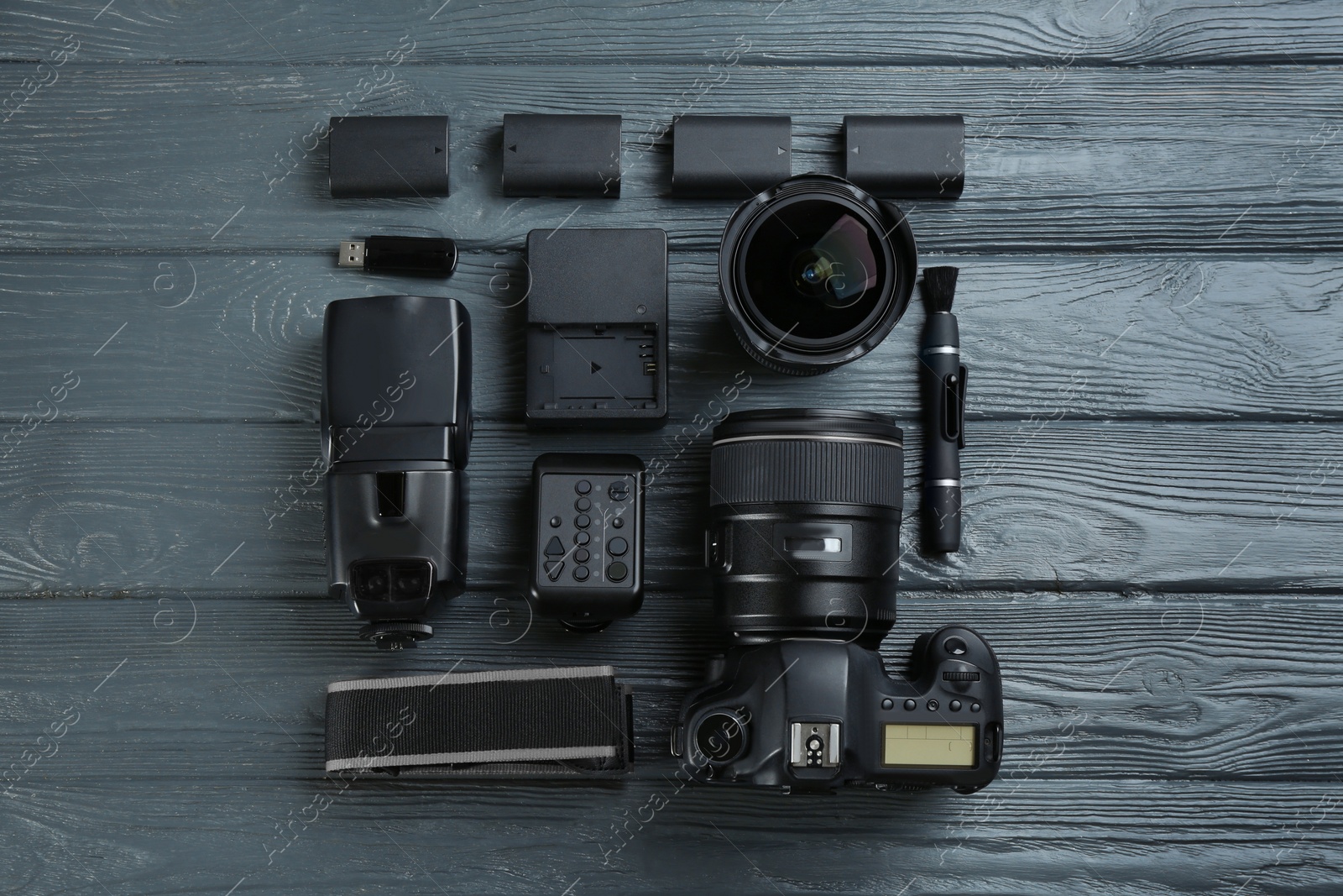 Photo of Flat lay composition with equipment for professional photographer on grey wooden table