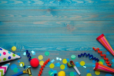 Flat lay composition with party items on light blue wooden table, space for text