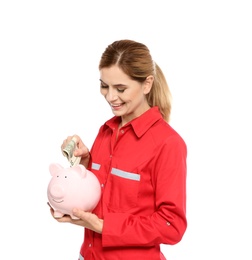 Photo of Portrait of female emergency doctor putting money into piggy bank on white background