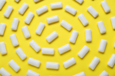 Tasty white chewing gums on yellow background, flat lay