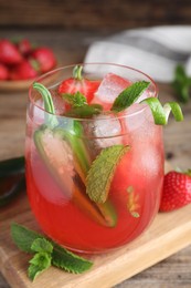 Photo of Spicy strawberry cocktail with jalapeno and mint on wooden table, closeup