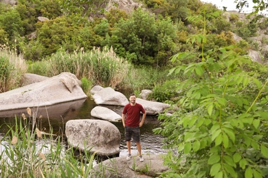 Photo of Man posing near river. Camping season