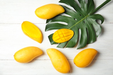 Photo of Flat lay composition with mango and tropical leaf on wooden background