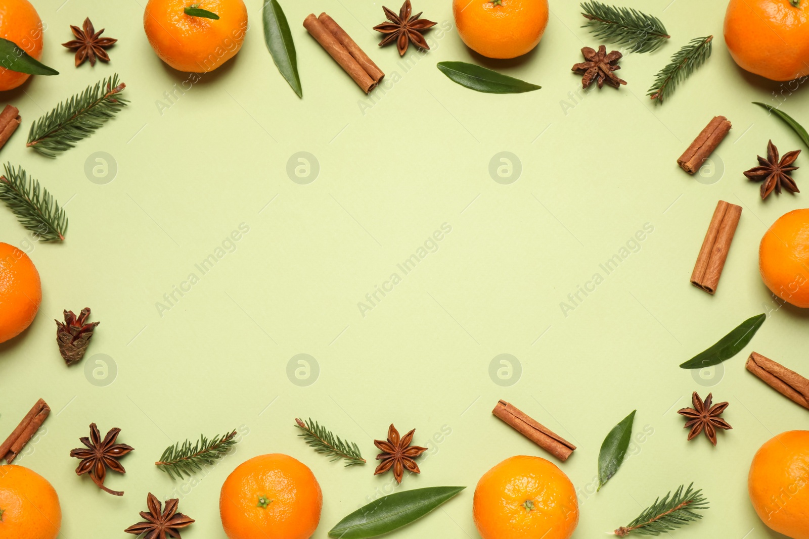 Photo of Frame made of fresh tangerines on light green background, flat lay. Christmas composition with space for text