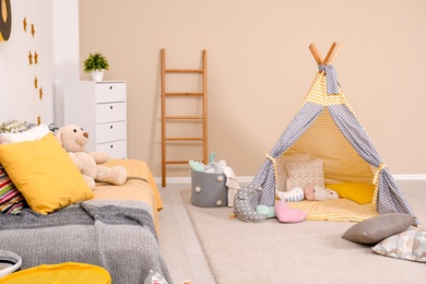 Cozy child room interior with bed, play tent and modern decor elements