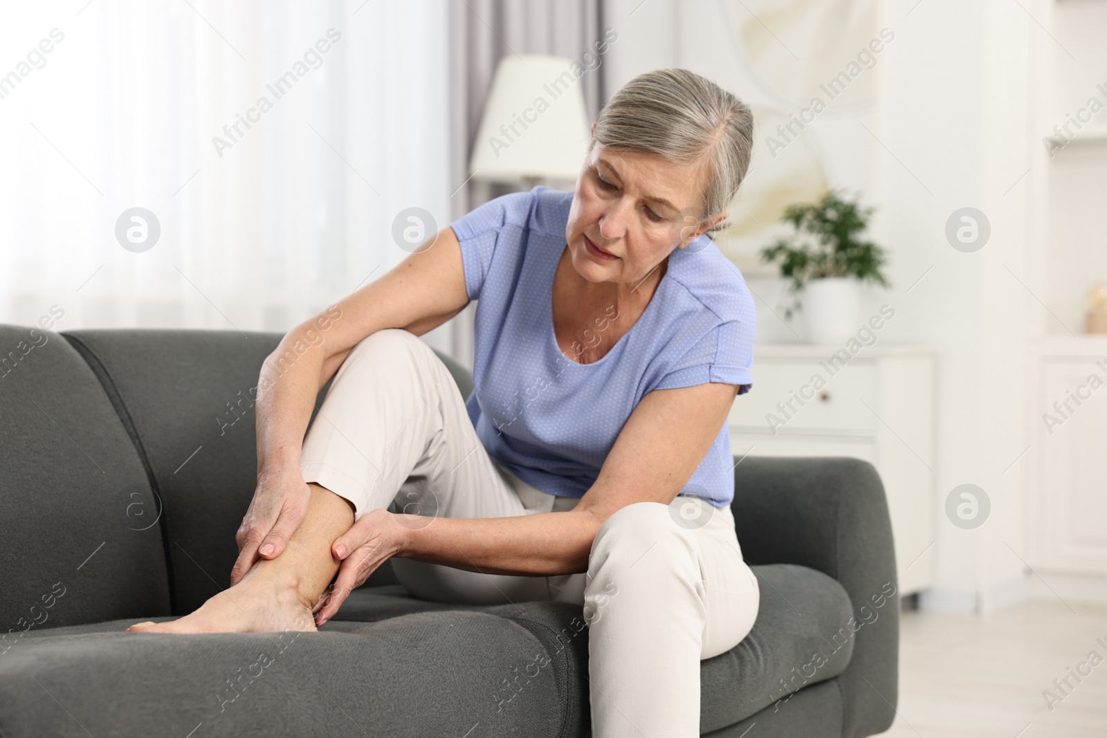 Photo of Arthritis symptoms. Woman suffering from pain in leg at home
