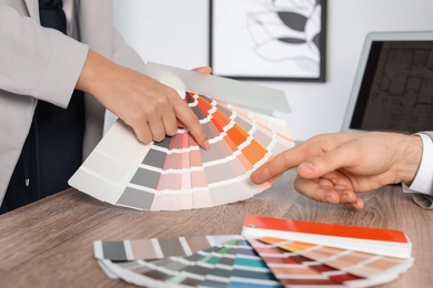 Team of designers working with color palette at office table, closeup