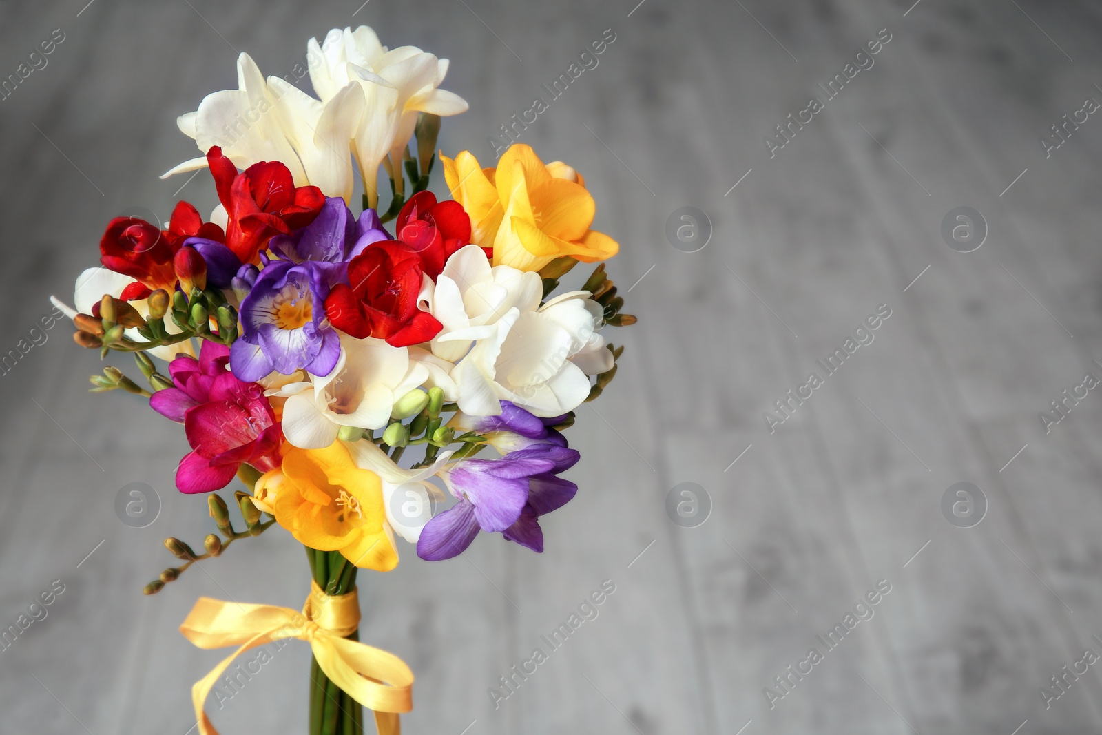 Photo of Beautiful freesia bouquet on blurred background