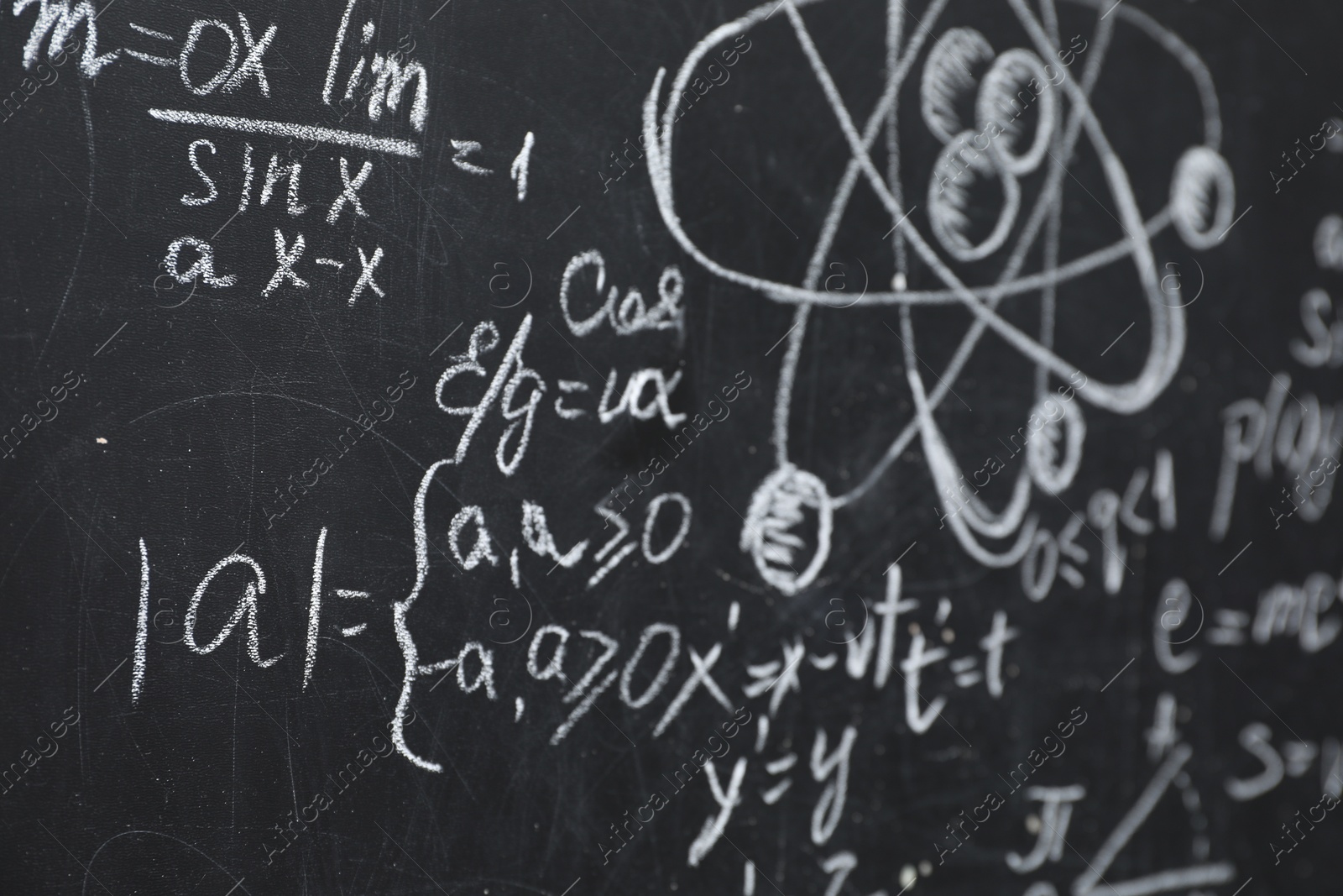 Photo of Many different physical formulas written with chalk on blackboard, closeup