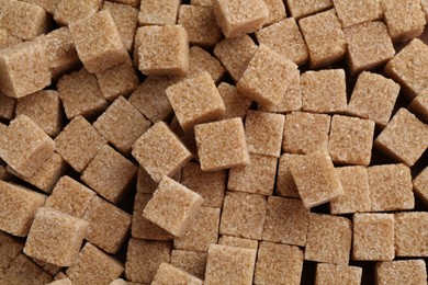 Photo of Brown sugar cubes as background, top view