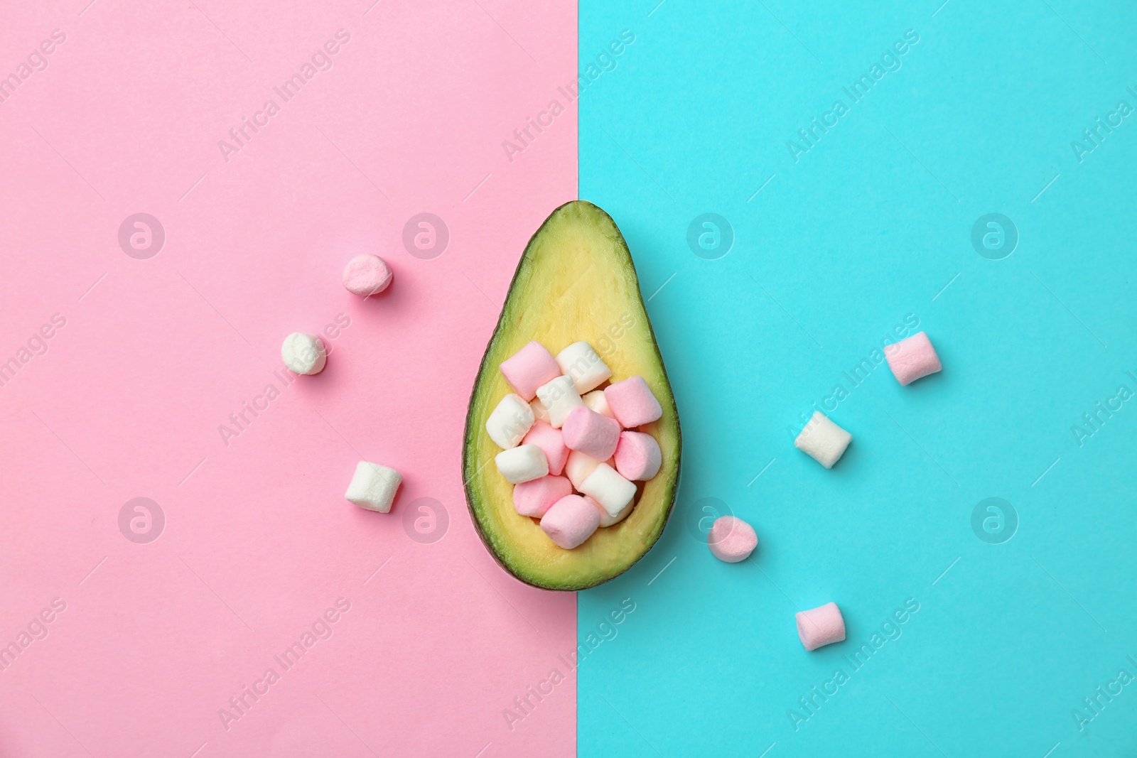 Photo of Composition with ripe avocado and marshmallows on color background, top view