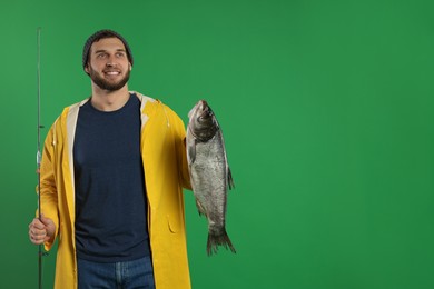 Photo of Fisherman with rod and catch on green background, space for text