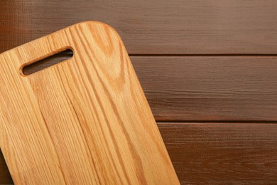 One new cutting board on wooden table, top view. Space for text