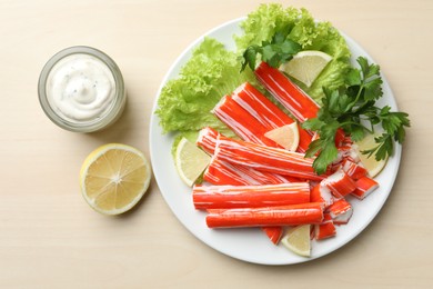 Delicious crab sticks served on wooden table, flat lay