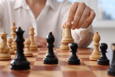 Photo of Woman playing chess during tournament at chessboard, closeup