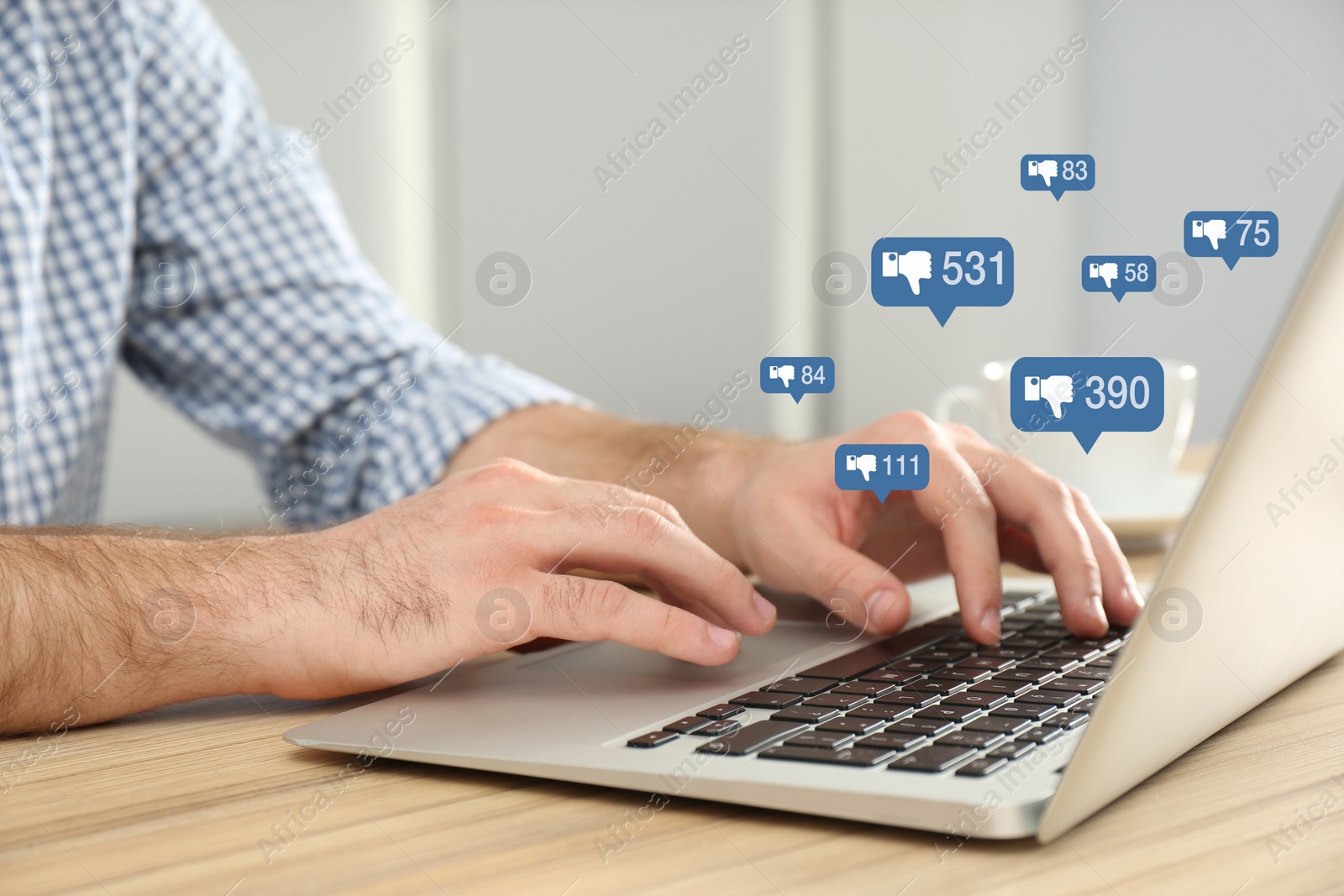 Image of Closeup view of young man using modern laptop at wooden table. Cyberbullying concept