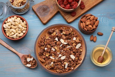 Tasty granola served with nuts and dry fruits on light blue wooden table, flat lay