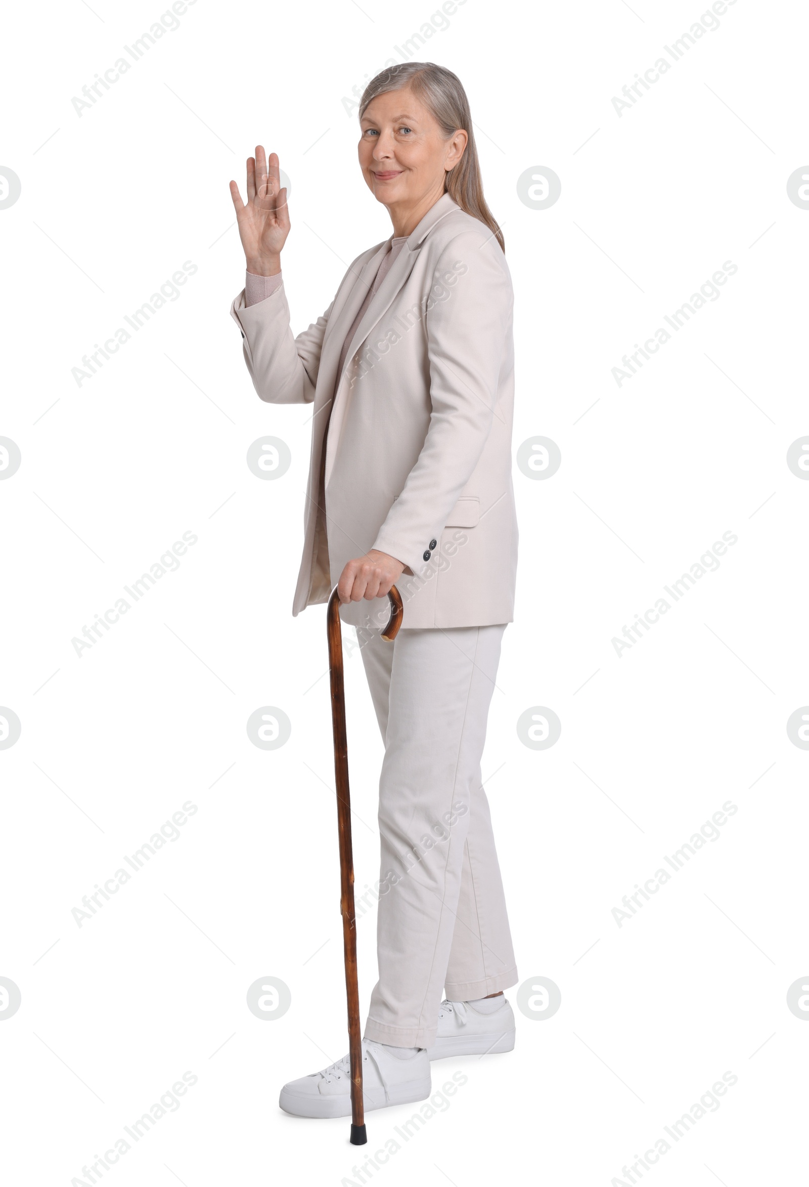 Photo of Senior woman with walking cane waving on white background