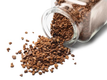 Overturned jar with chicory granules on white background