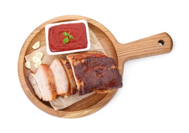 Photo of Pieces of tasty baked pork belly and sauce isolated on white, top view