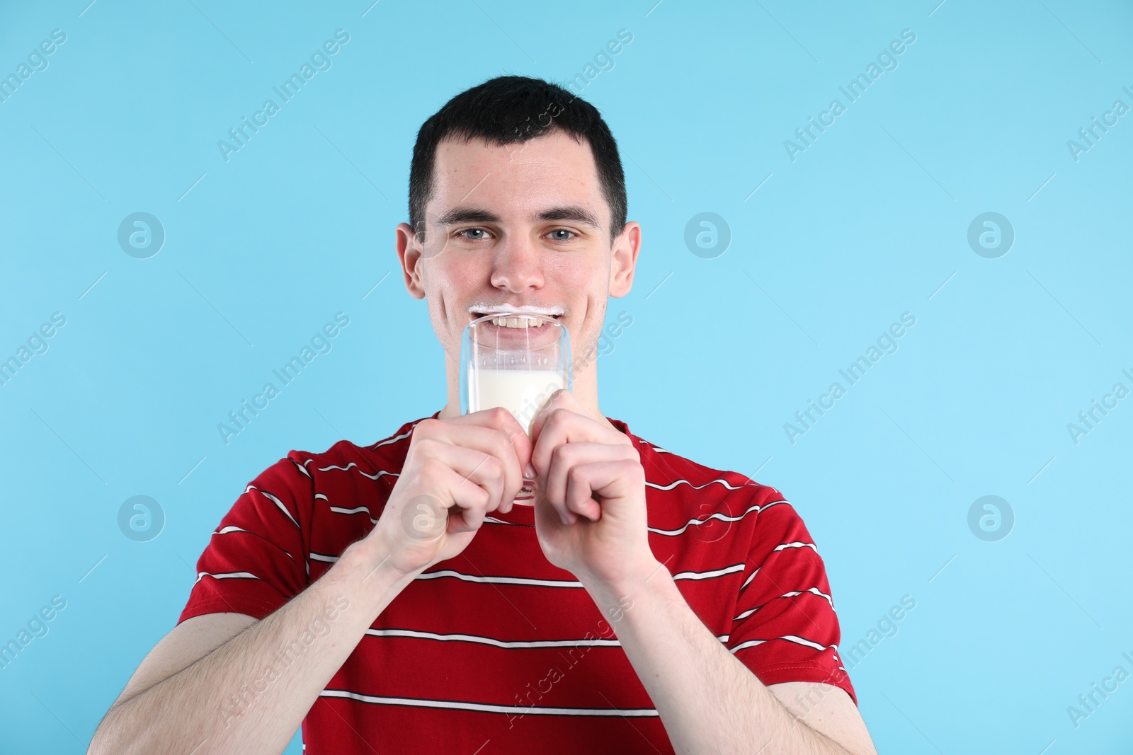 Photo of Milk mustache left after dairy product. Man drinking milk on light blue background