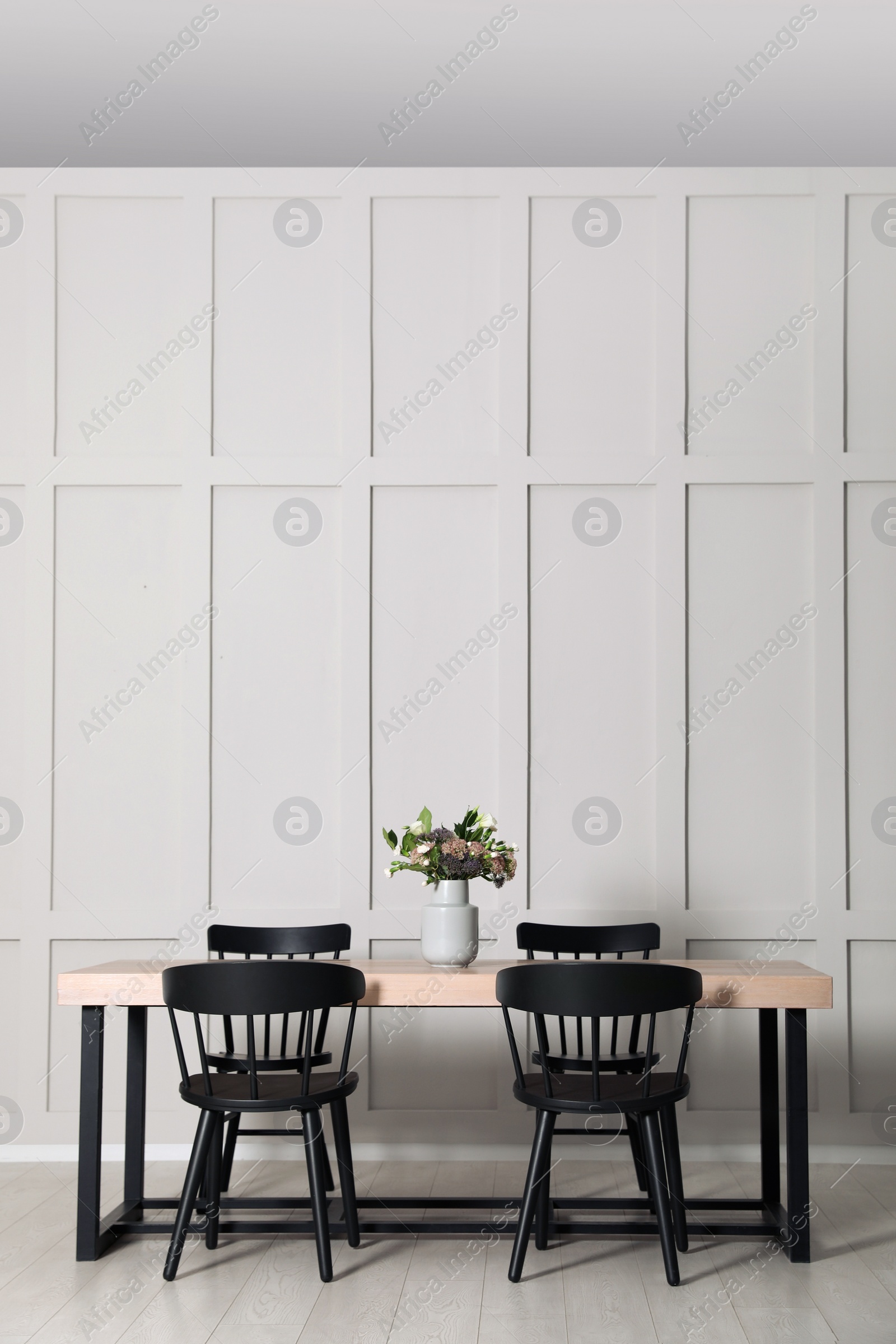 Photo of Stylish dining room interior with wooden table and chairs near molding wall, space for text