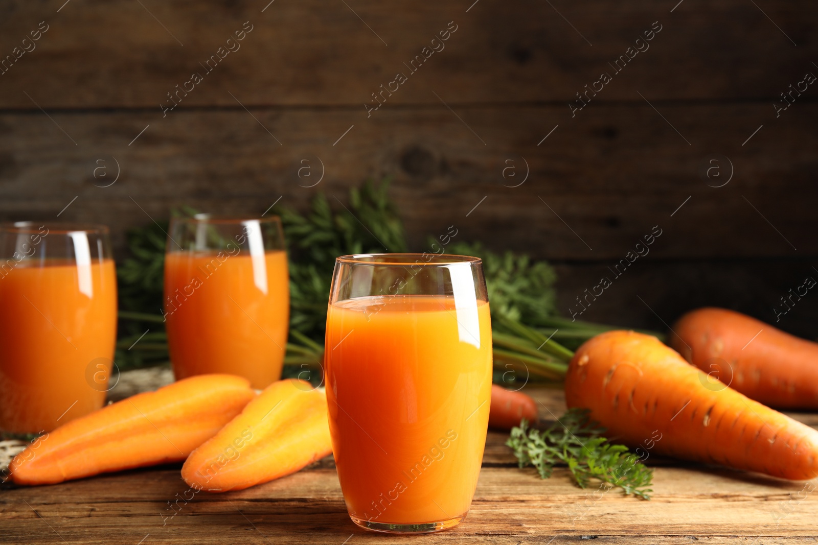 Photo of Freshly made carrot juice on wooden table