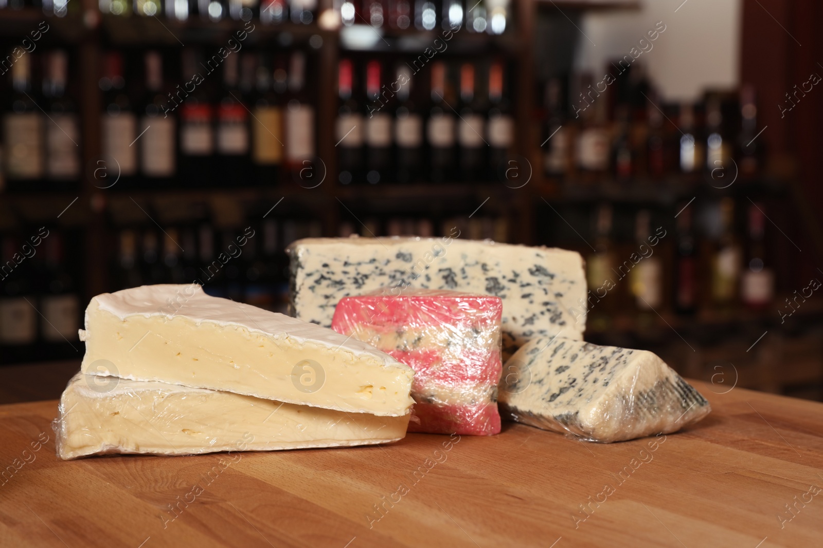 Photo of Different types of delicious cheeses on counter in store