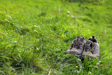 Photo of Hiking boots in green mountain valley. Summer camping