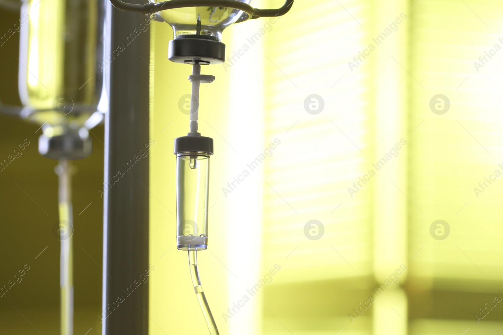 Photo of IV drip against blurred yellow background, space for text