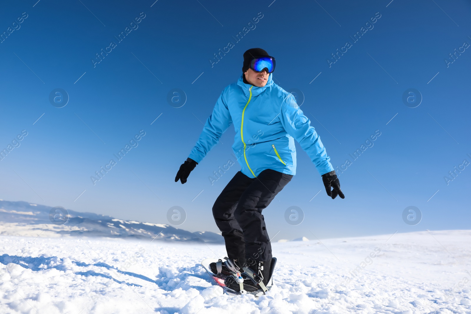 Photo of Man snowboarding on snowy hill. Winter vacation