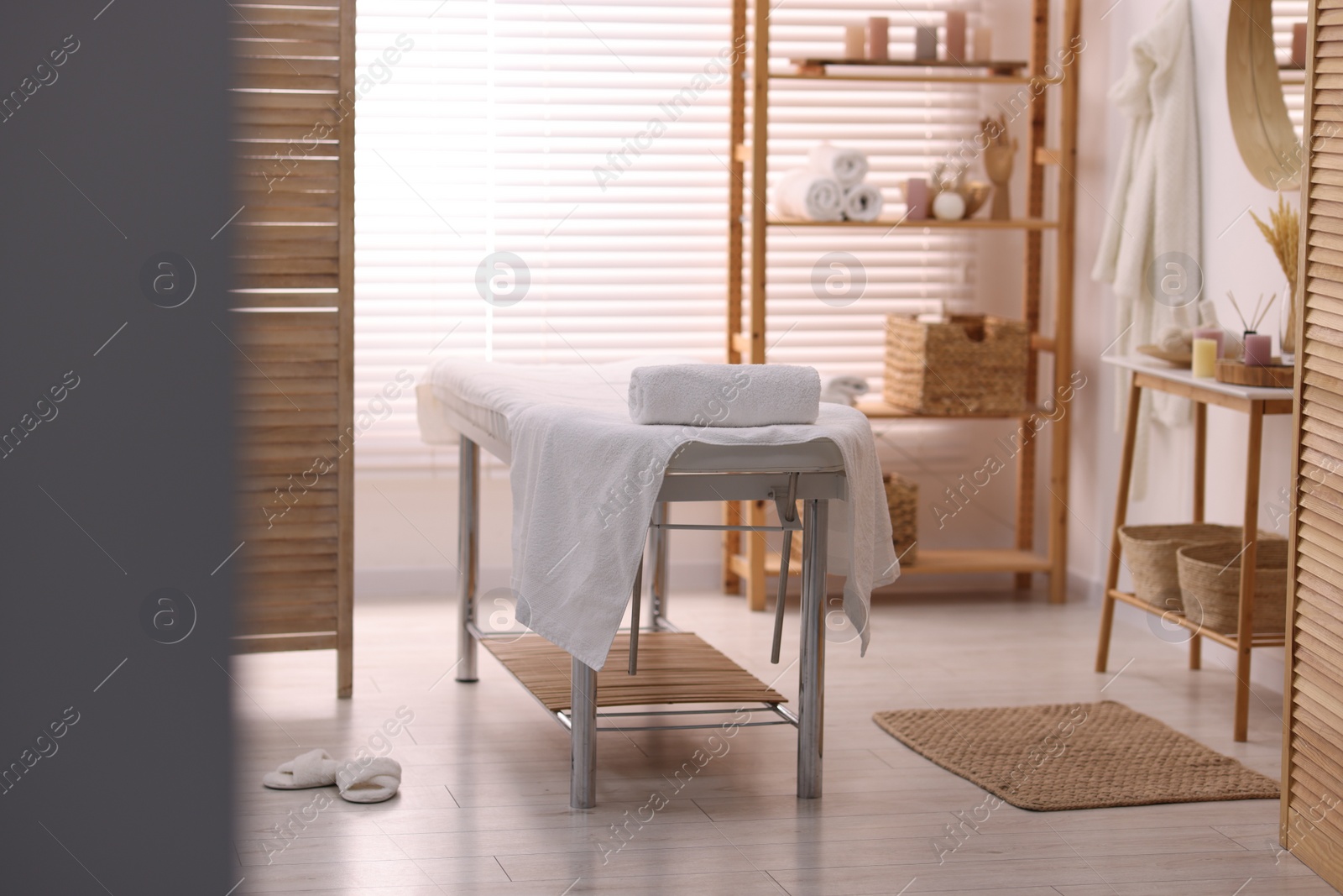 Photo of Comfortable massage table with clean towels in spa center